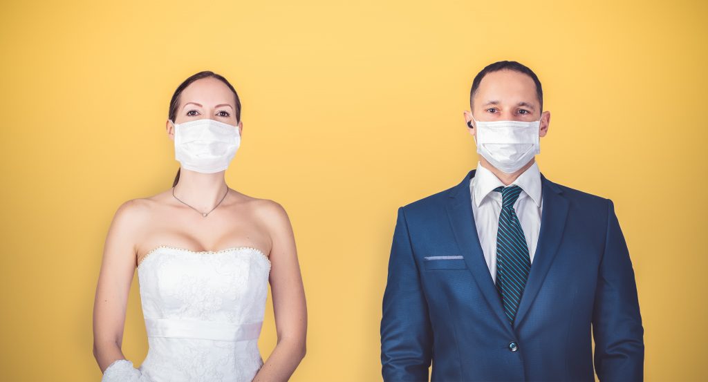 Wedding couple with wearing protective medical masks.