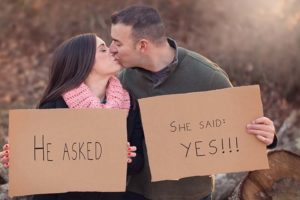 Engaged couple with sign