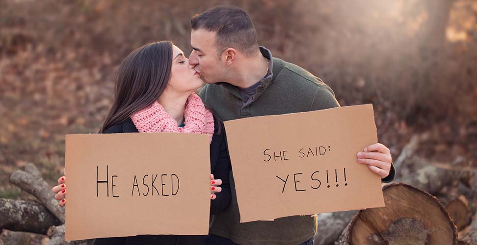 Engaged couple with sign