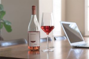 Bottle and glass of Flat Top Wine with computer